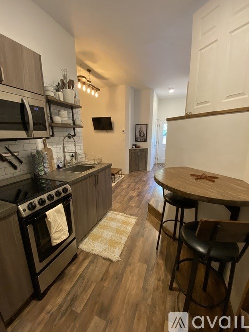 A kitchen with a wood stove and a table with two chairs.