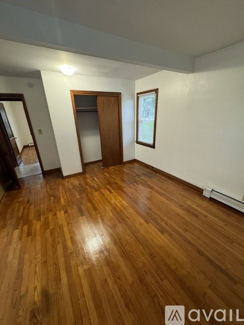 A room with wooden flooring and a door.