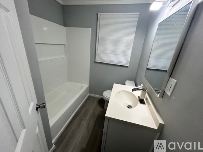 A bathroom with a white sink and a white bathtub.