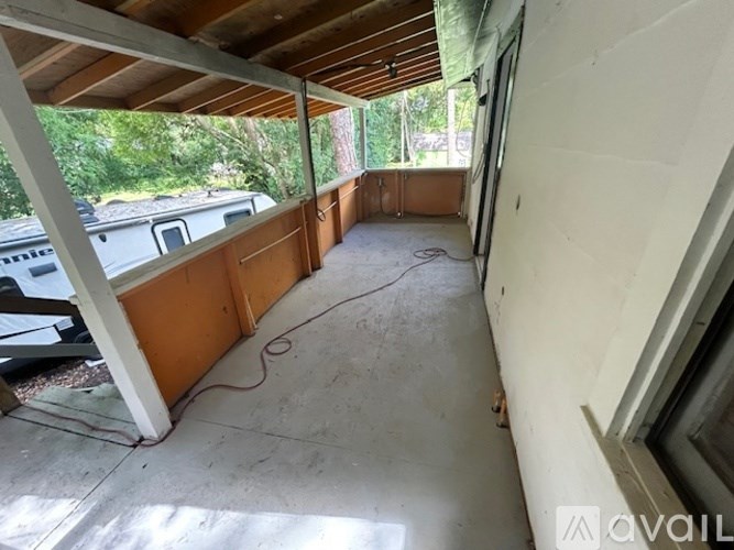 A room with a wooden ceiling and a window on the right side.