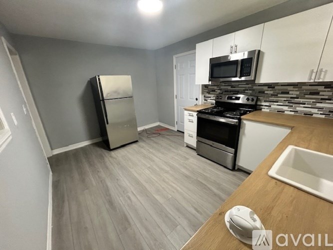 A kitchen with a refrigerator, stove, and microwave.