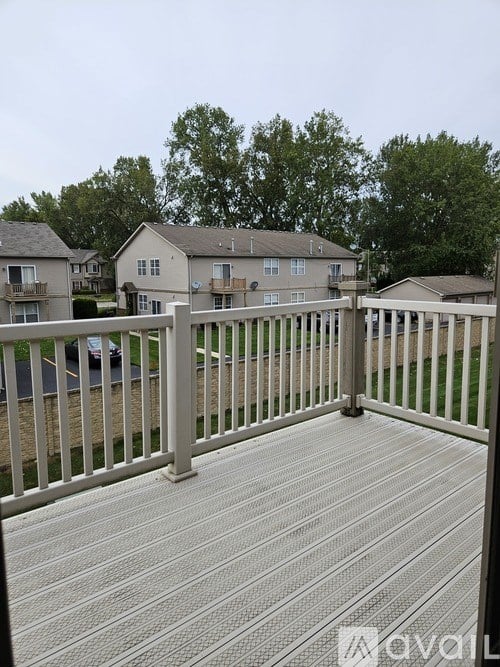 A deck with a railing and a car parked in the background.