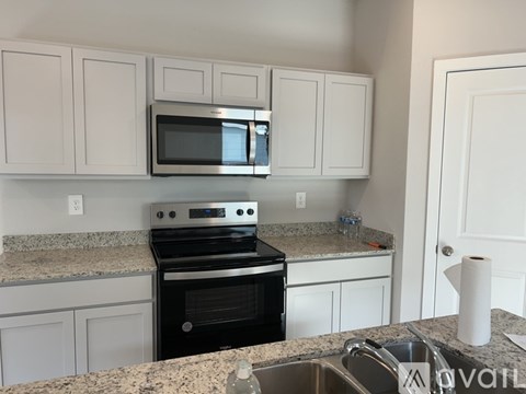 A kitchen with a granite countertop and white cabinets.
