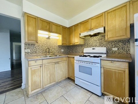 A kitchen with wooden cabinets and a white stove top oven.
