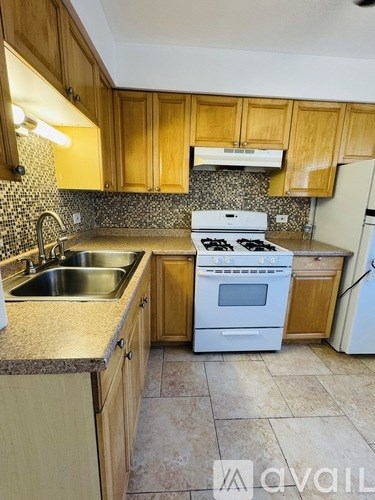 A kitchen with a white stove top oven and a white refrigerator.