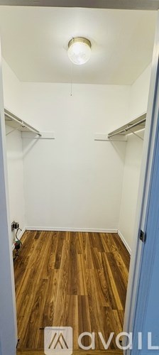A room with a wooden floor and a white ceiling with a light on.