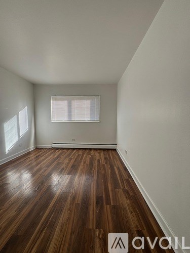 A room with wooden flooring and a window.