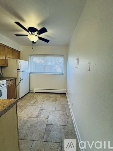 A kitchen with a ceiling fan and a window.