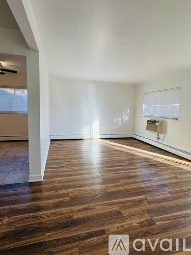 A room with wooden flooring and white walls.