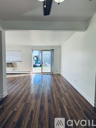 A room with wooden floors and a sliding glass door.