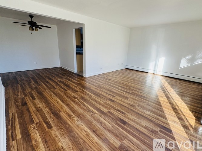 A room with wooden flooring and a ceiling fan.