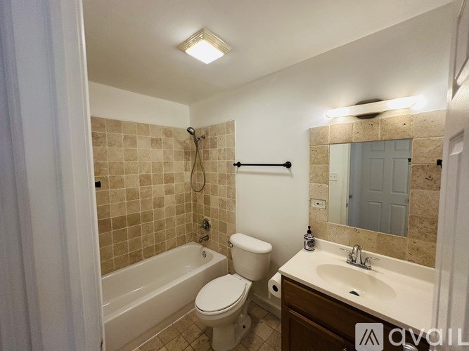 A bathroom with a toilet, sink, and bathtub.
