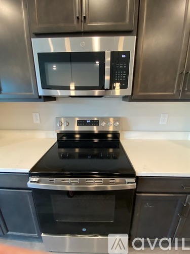 A modern kitchen with a stove top oven and microwave above it.