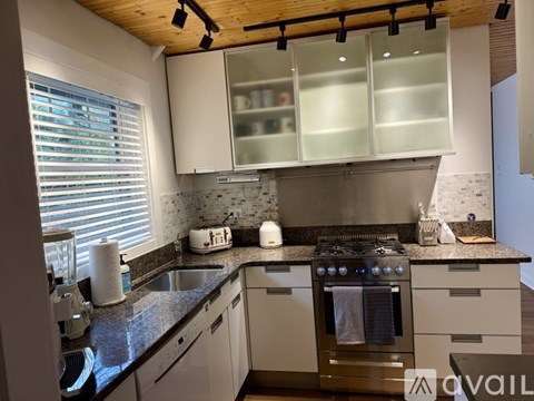 A modern kitchen with a stove top oven and a sink.