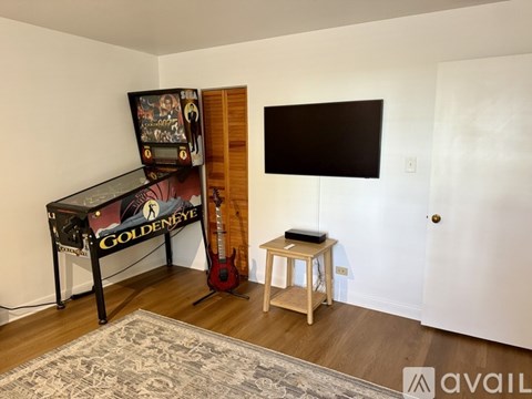 A room with a piano, a guitar, and a TV.