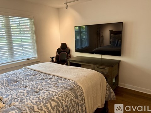 A bedroom with a bed, desk, and chair.