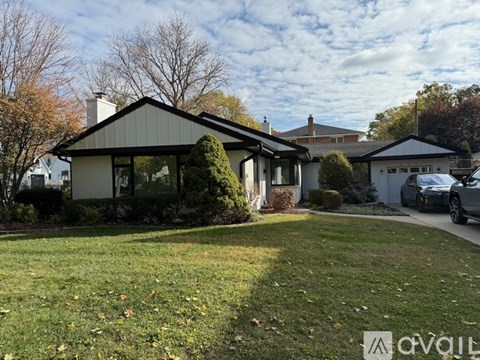 A house with a white garage door and a car parked in front.
