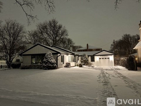 A house with a snow-covered driveway in front of it.