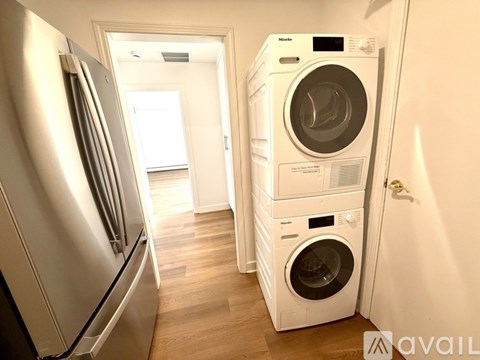 A white washing machine and fridge in a kitchen.