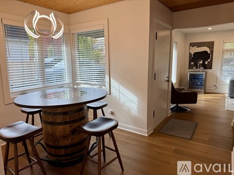 A modern dining area with a round table and bar stools.