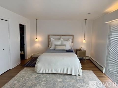 A bedroom with a large bed and two lamps.