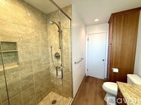 A tiled bathroom with a walk-in shower and a toilet.