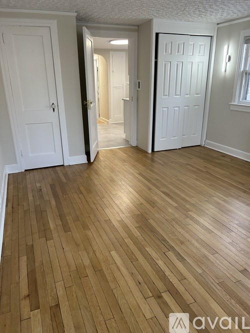 A room with wooden flooring and white doors.