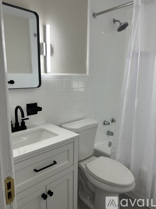 A white bathroom with a toilet, sink, and shower.