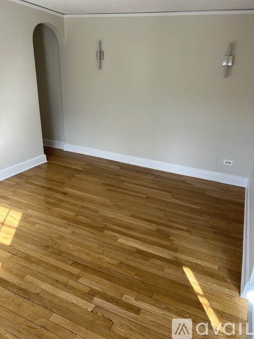 A room with wooden flooring and a white wall.