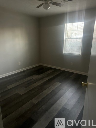 A room with a wooden floor and a ceiling fan.