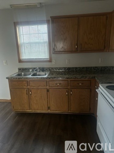 A kitchen with wooden cabinets and a granite countertop.