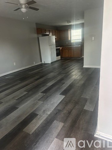 A room with wooden flooring and a ceiling fan.