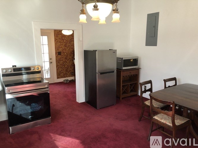 A kitchen with a refrigerator, oven, and microwave.