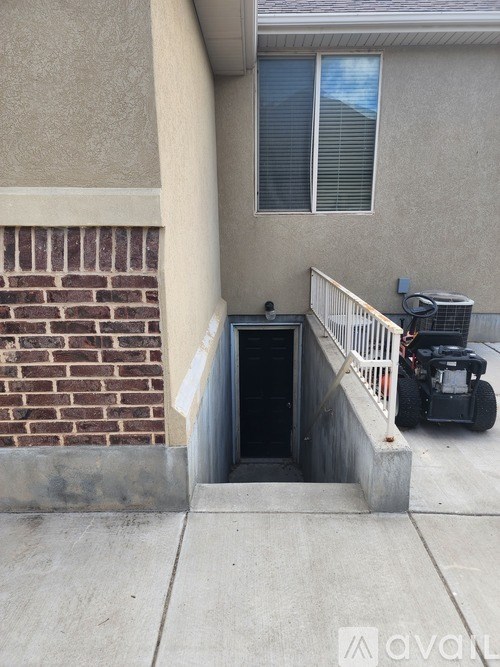 A small black box is on the ground next to a brick wall.