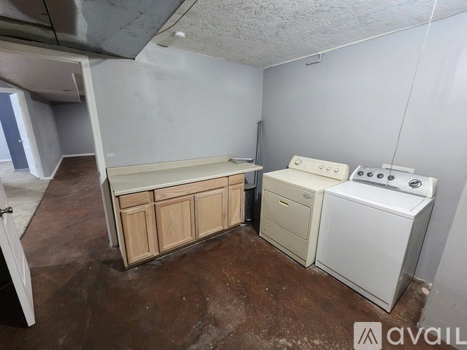 A kitchen area with a washing machine and a cabinet.