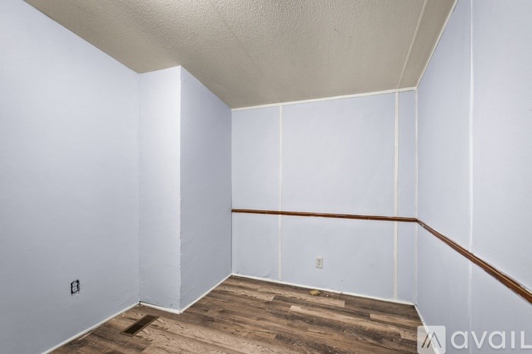 A room with white walls and wooden flooring.