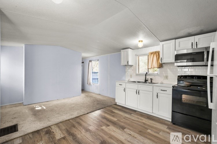 A kitchen with white cabinets and a black stove top oven.