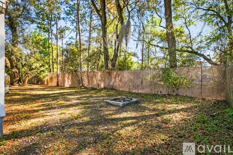 A backyard with a fence and trees.