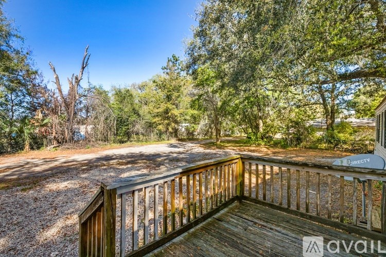 A wooden deck overlooks a wooded area.