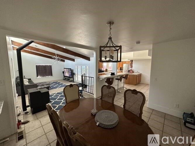 A dining room with a wooden table and chairs.