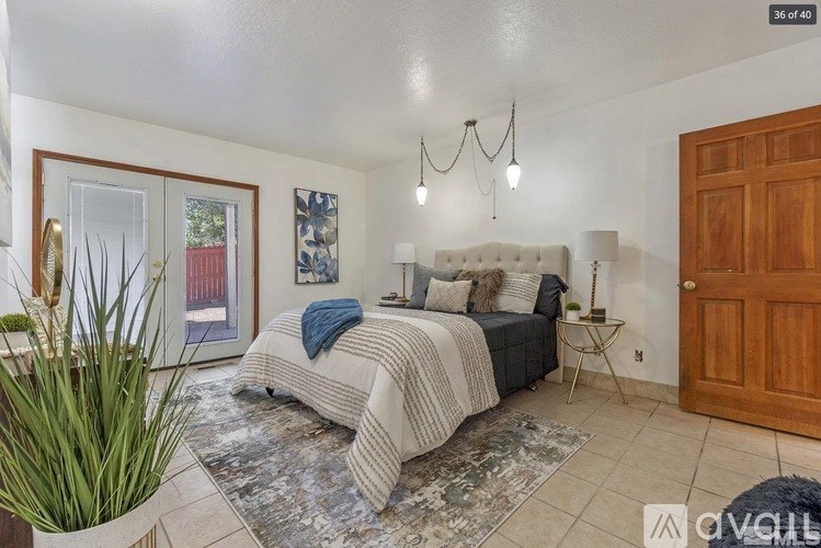 A bedroom with a large bed and a rug in front of it.