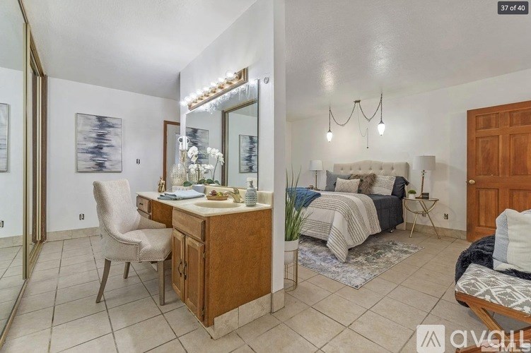 A bedroom with a bed, a desk, and a chair.