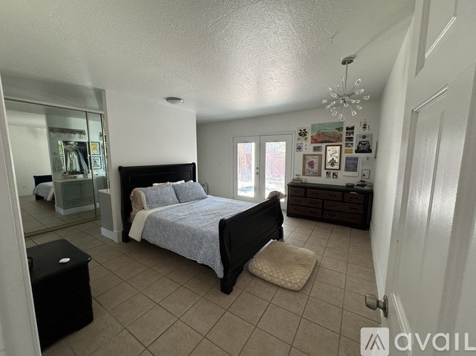 A bedroom with a bed, dresser, and mirror.