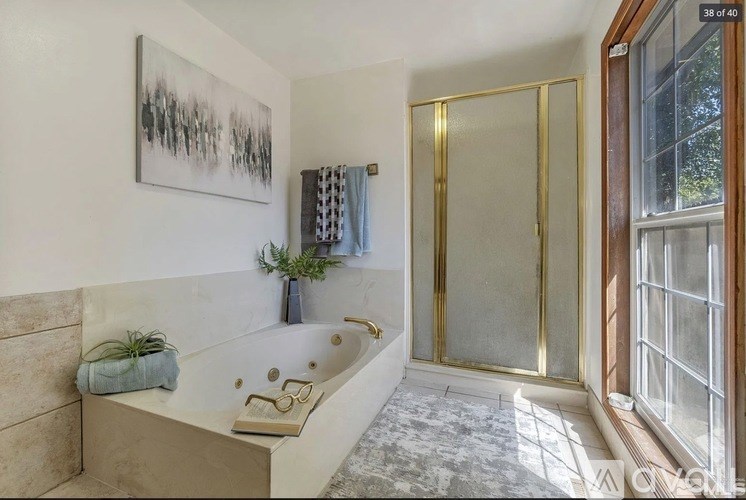 A bathroom with a large tub and a painting on the wall.