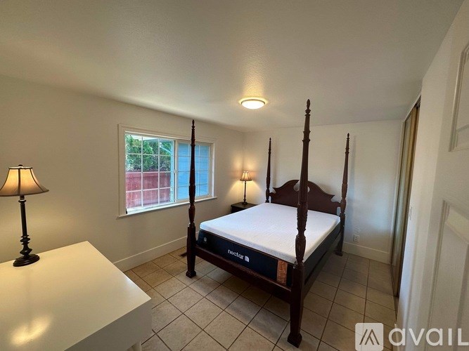 A bedroom with a four poster bed and a window.