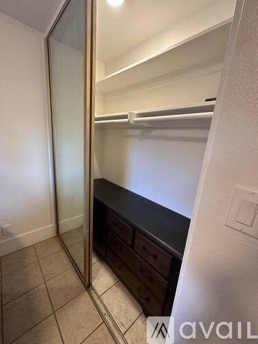A bathroom with a mirror, a vanity, and a light switch.