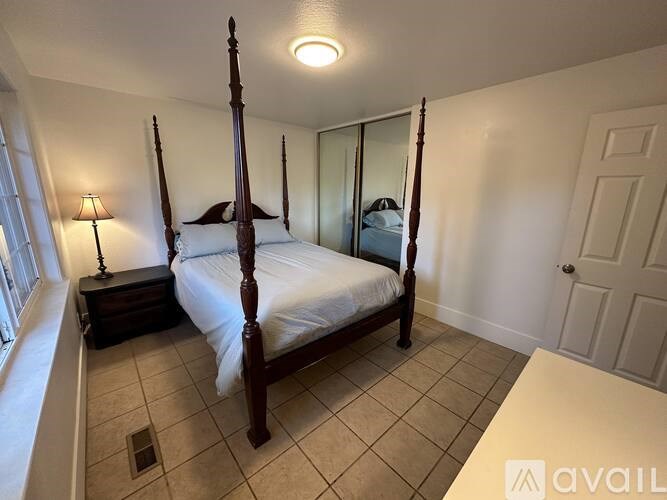 A bedroom with a four poster bed and a window.