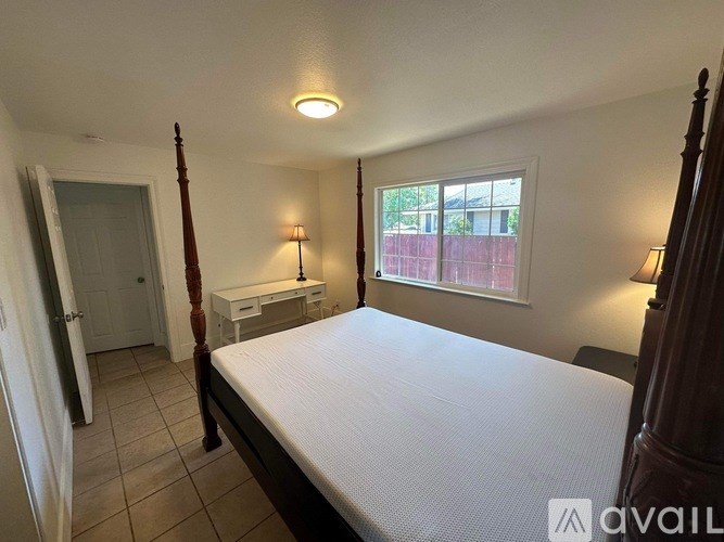 A bedroom with a bed, desk, and chair.