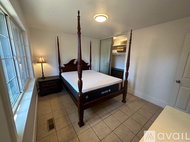 A bedroom with a four poster bed and a window.