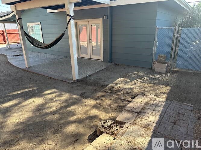 A blue house with a hammock outside.